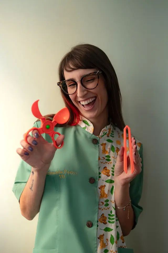 Amanda Parro segurando recursos utilizados em Terapia Ocupacional